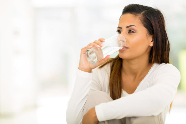 Woman drinking water while sitting